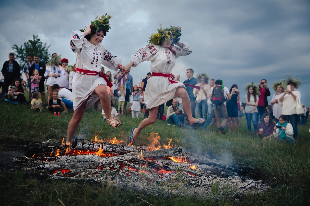 Two young women binfire jumping on Ivan Kupala summer solstice