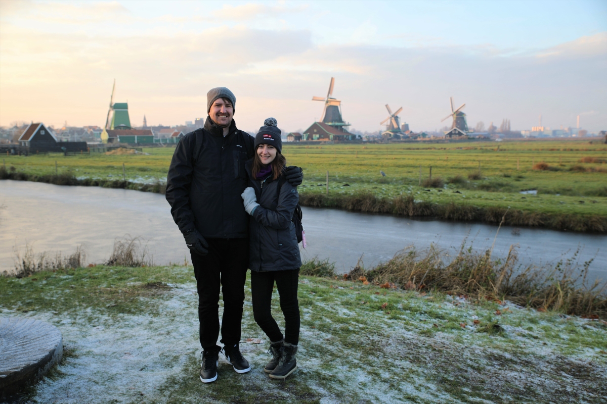 Couple on tour posing in the Netherlands with windmills